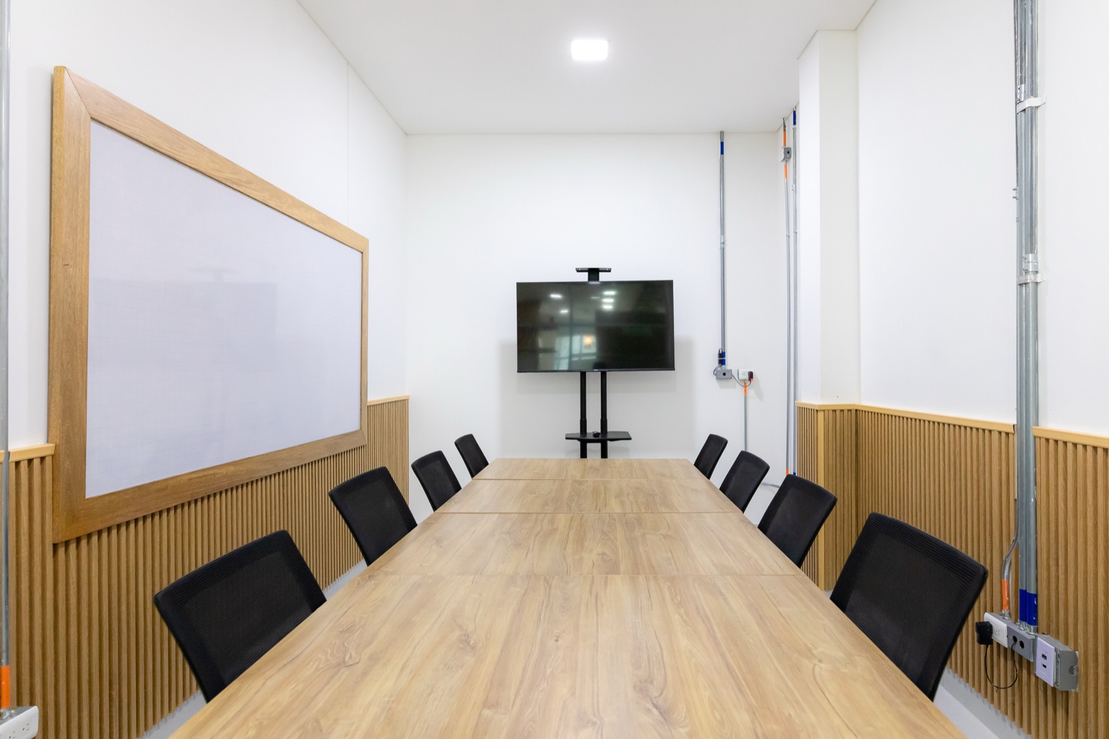Sala de reuniones de Plaza U con tablero y televisor