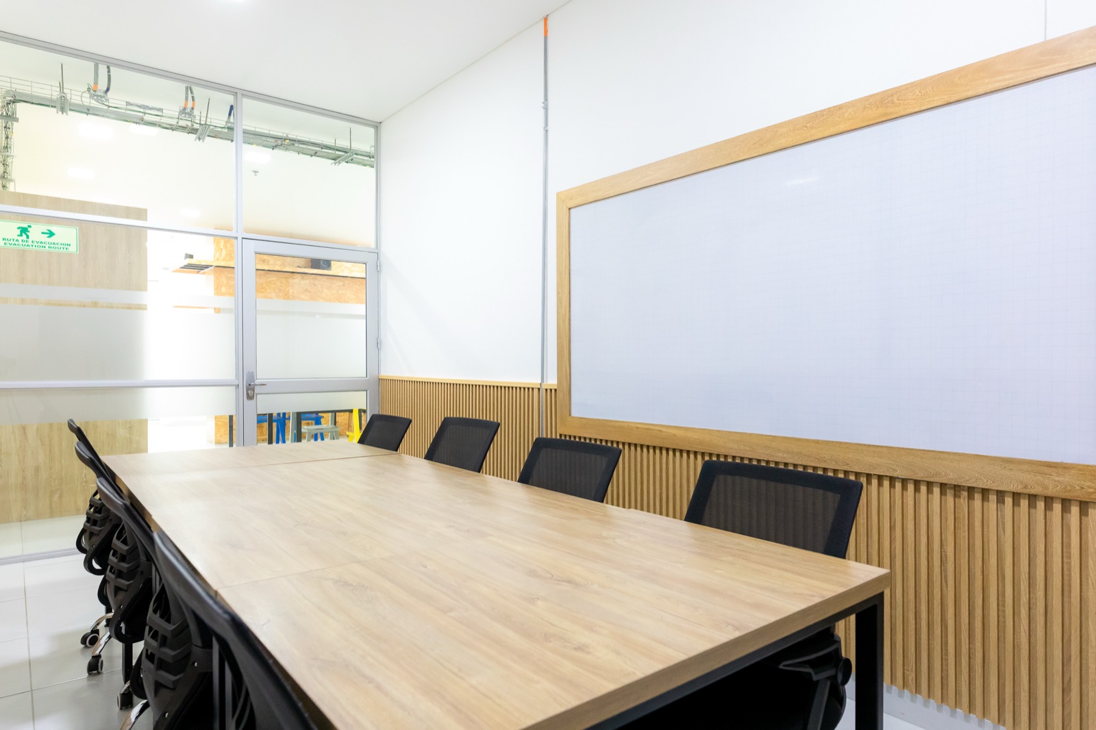 Sala de reuniones de Plaza U con tablero y mesa para el equipo